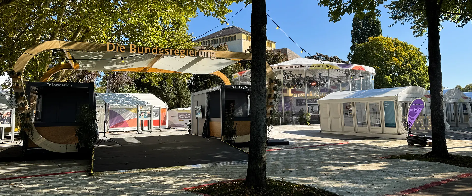 Tag der Deutschen Einheit 2025 in Saarbrücken: Blick auf die Präsentationsfläche der Bundesregierung mit Zeltaufbauten. Im Hintergrund das Saarländische Staatstheater.